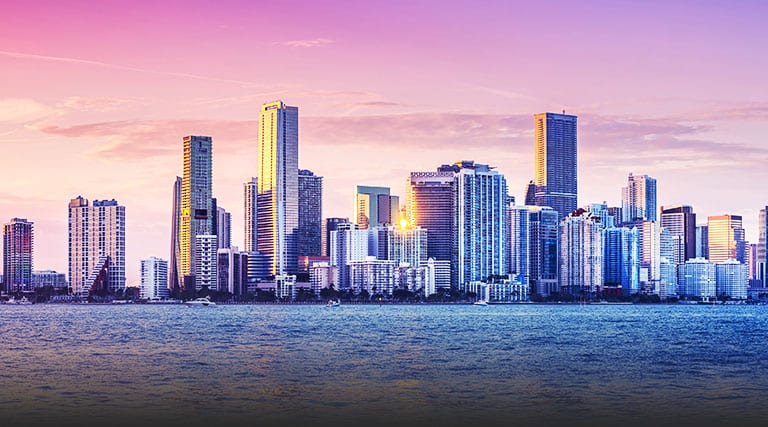 A cityscape view at sunset from across water