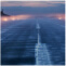 A foggy airport runway lined with lights at dusk