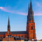A landmark building in Uppsala, Sweden set against a blue sky and trees