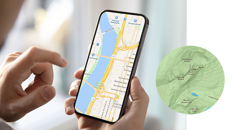 A pair of hands holding a mobile phone displaying a highway map