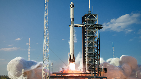 A rocket launch in progress under a clear pale blue sky
