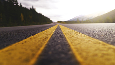A road with a closeup image of a double yellow center divider 