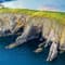 Large sweeping cliffs leading into a bright blue body of water