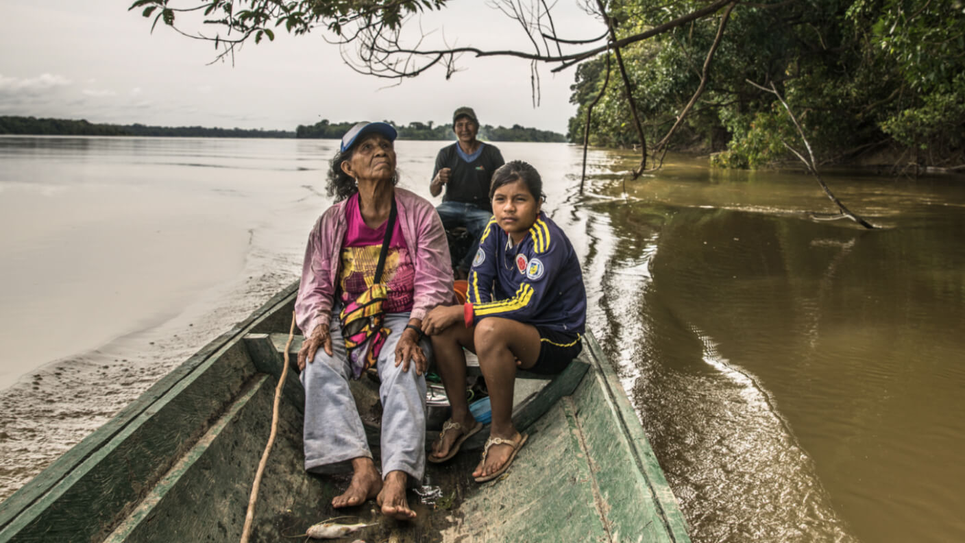 A woman and a young child on a canoe sailing down a river