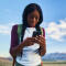Hiker in the mountains looking at her cell phone
