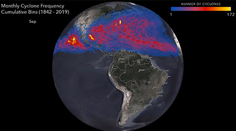 A nighttime view of the Earth from space showing a highlighted red and blue cyclone sweeping through the northern hemisphere