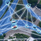 An aerial view of a highway with roads highlighted in blue and white lines that show the distance between vehicles