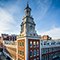 The corner of a majestic brick building bathed in light on the Yale University campus