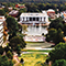 An aerial photo of a sprawling campus filled with red brick buildings and green tree-lined open spaces