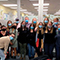 A group of people wearing face coverings and standing together indoors